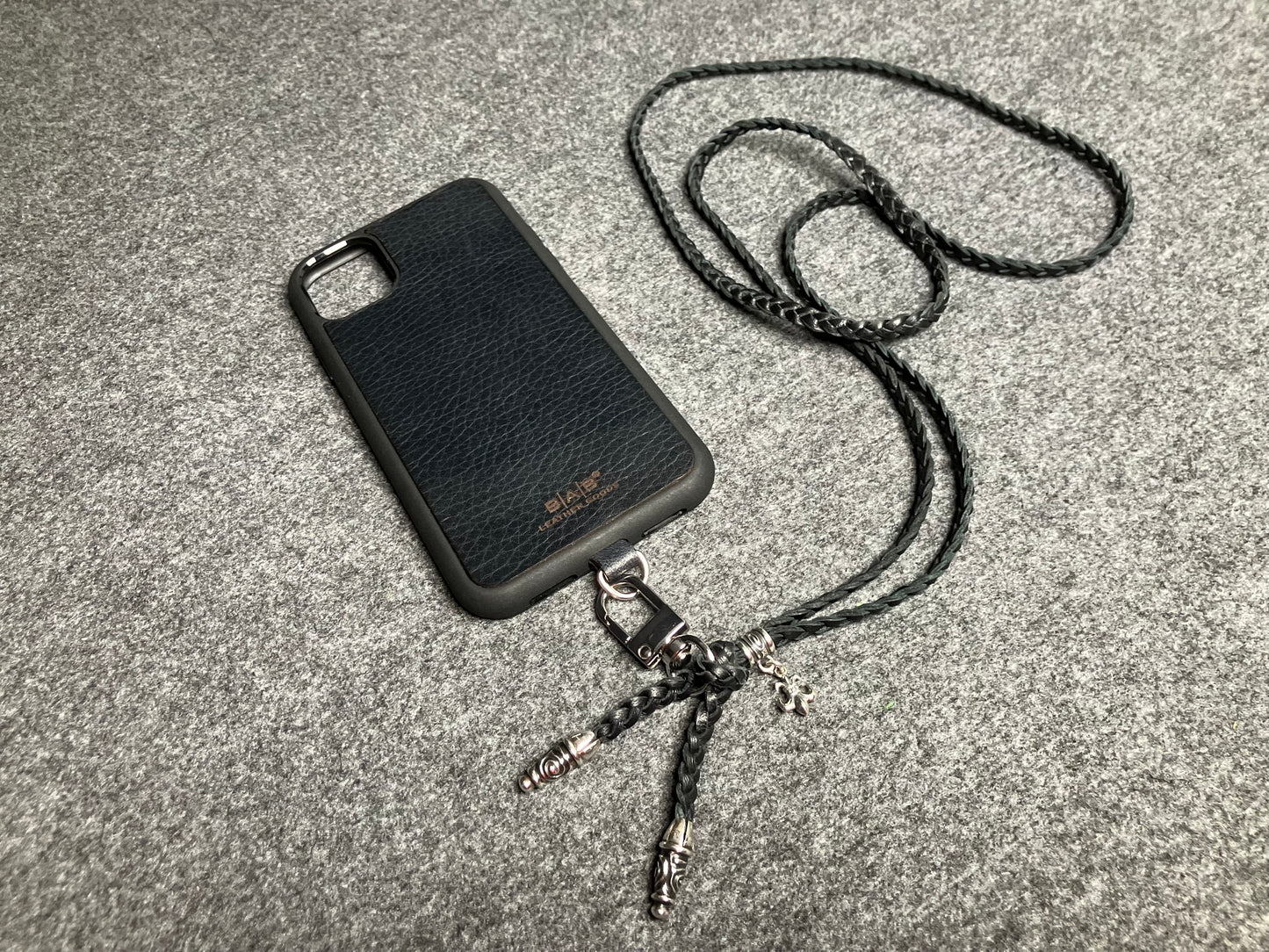 Capa/Suporte para iPhone de Couro Flor Integral/microfibra. 2 Terminais Espirais, 1 Pino em Espiral com Argola e 1 Pingente Fleur de Lys, todos de Prata 925 & Crossbody/Colar/Pulseira de Couro com 3 fios duplos trançados à mão, Marrom ou Preto.- KC45i