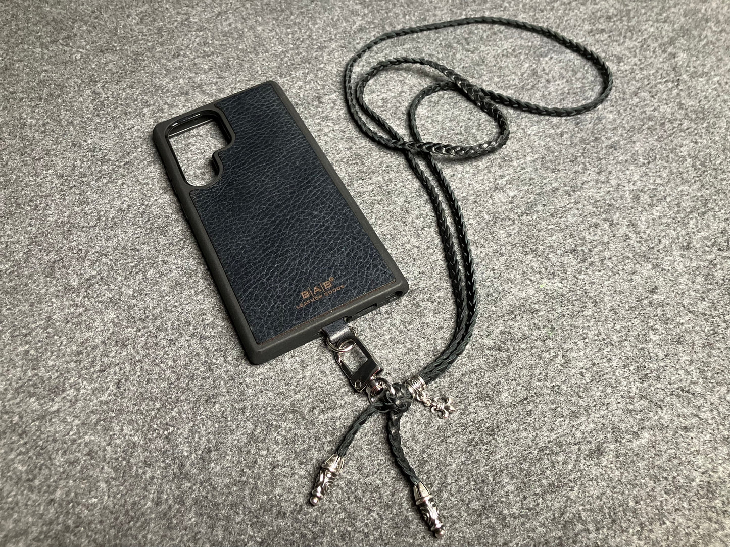 Capa/Suporte para Samsung de Couro Flor Integral/microfibra. 2 Terminais Espirais, 1 Pino em Espiral com Argola e 1 Pingente Fleur de Lys, todos de Prata 925 & Crossbody/Colar/Pulseira de Couro com 3 fios duplos trançados à mão, Marrom ou Preto.- KC45S