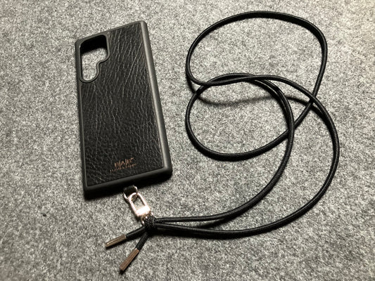 Funda/Soporte para Samsung de Cuero Genuino Full-Grain curtido vegetal al tanino cortados y grabados con láser/microfibra & Crossbody/Collar/Gargantilla/Pulsera de Cuerda Elástica Negra con 1 Mosquetón y 2 Terminales plateados.- KCS53