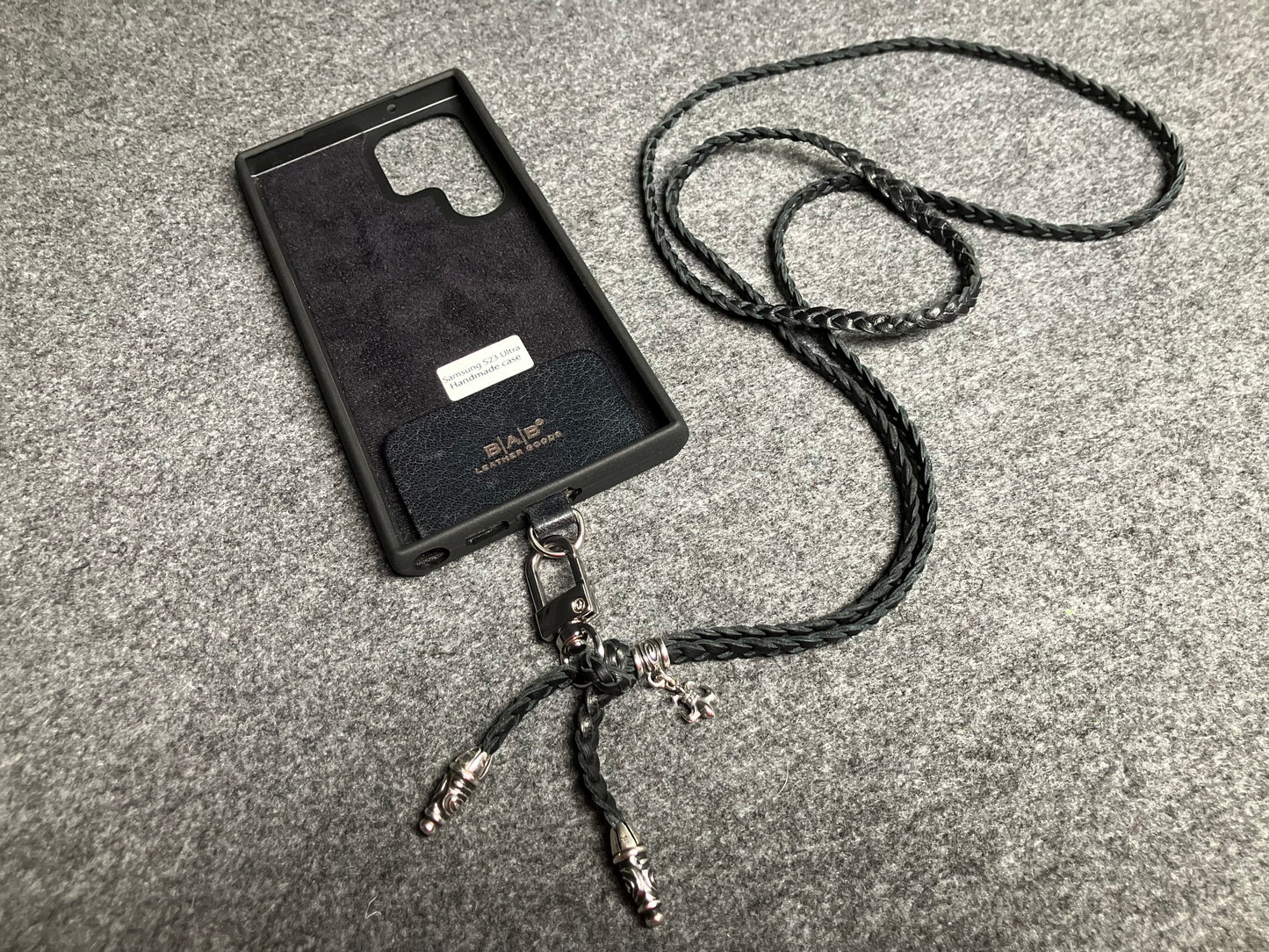 Capa/Suporte para Samsung de Couro Flor Integral/microfibra. 2 Terminais Espirais, 1 Pino em Espiral com Argola e 1 Pingente Fleur de Lys, todos de Prata 925 & Crossbody/Colar/Pulseira de Couro com 3 fios duplos trançados à mão, Marrom ou Preto.- KC45S