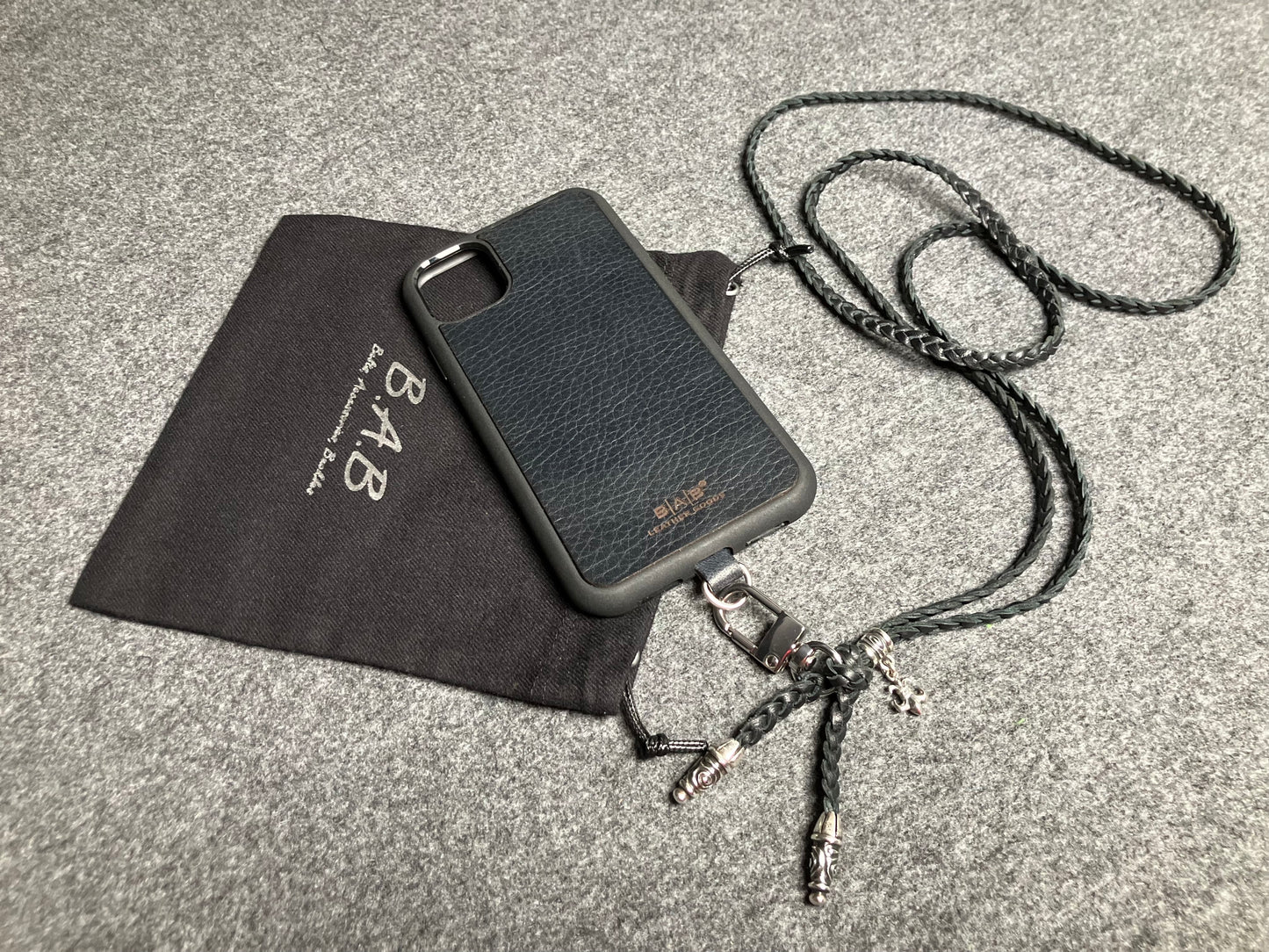 Capa/Suporte para iPhone de Couro Flor Integral/microfibra. 2 Terminais Espirais, 1 Pino em Espiral com Argola e 1 Pingente Fleur de Lys, todos de Prata 925 & Crossbody/Colar/Pulseira de Couro com 3 fios duplos trançados à mão, Marrom ou Preto.- KC45i