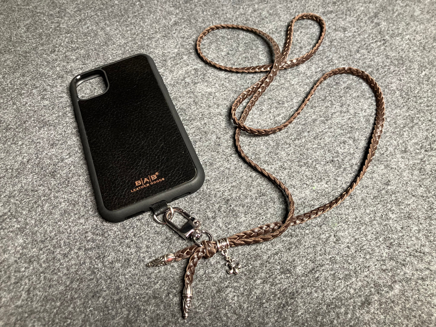 Capa/Suporte para iPhone de Couro Flor Integral/microfibra. 2 Terminais Espirais, 1 Pino em Espiral com Argola e 1 Pingente Fleur de Lys, todos de Prata 925 & Crossbody/Colar/Pulseira de Couro com 3 fios duplos trançados à mão, Marrom ou Preto.- KC45i