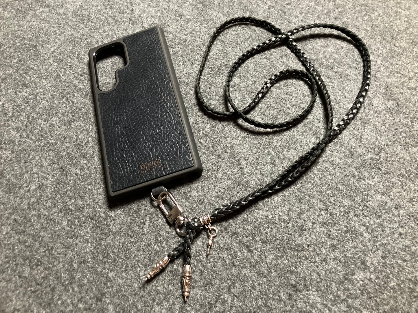 Coque/Support en Cuir Véritable Pleine Fleur tanné végétal Samsung/microfibre. 2 Bornes en Spirale, 1 Épingle en Spirale avec anneau et 1 Pendentif Poignard, Argent 925 & Bandoulière/Collier/Bracelet 3 brins tressés à la main, Marron ou Noir.- KC32S