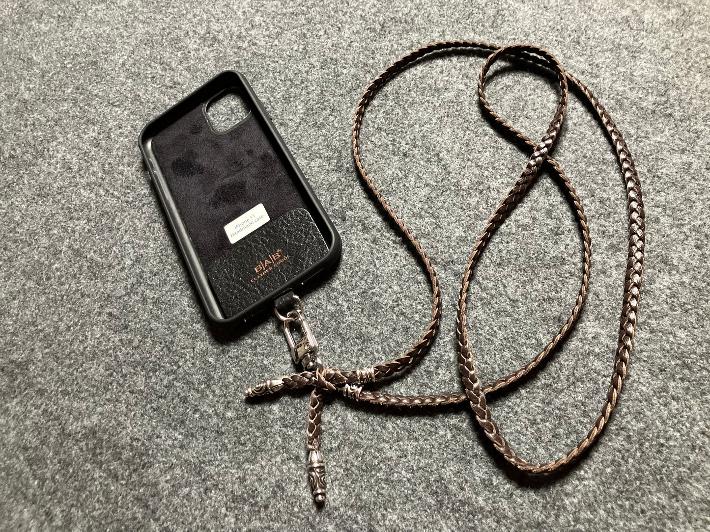 Capa/Suporte para iPhone de Couro Genuíno Flor Integral cortados e gravados a laser/microfibra. 2 Terminais Espirais e 2 Pinos Espirais, todos feitos de Prata 925 & Crossbody/Colar/Pulseira com três fios duplos trançados à mão, Marrom ou Preto.- KC43i