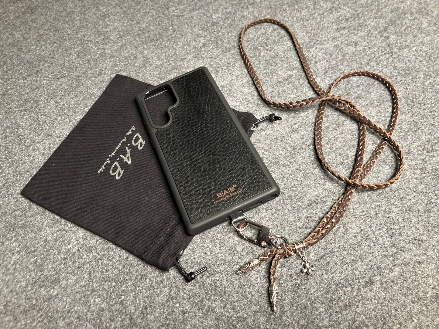 Capa/Suporte para Samsung de Couro Flor Integral/microfibra. 2 Terminais Espirais, 1 Pino em Espiral com Argola e 1 Pingente Fleur de Lys, todos de Prata 925 & Crossbody/Colar/Pulseira de Couro com 3 fios duplos trançados à mão, Marrom ou Preto.- KC45S