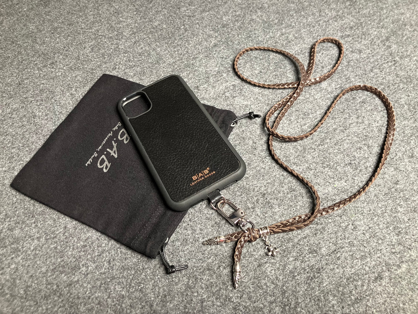 Capa/Suporte para iPhone de Couro Flor Integral/microfibra. 2 Terminais Espirais, 1 Pino em Espiral com Argola e 1 Pingente Fleur de Lys, todos de Prata 925 & Crossbody/Colar/Pulseira de Couro com 3 fios duplos trançados à mão, Marrom ou Preto.- KC45i