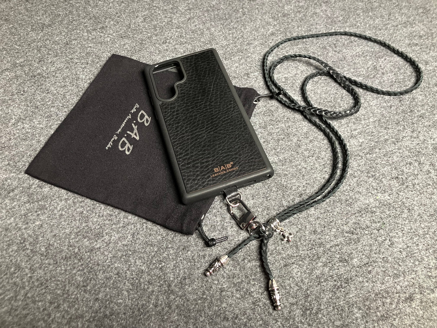 Capa/Suporte para Samsung de Couro Flor Integral/microfibra. 2 Terminais Espirais, 1 Pino em Espiral com Argola e 1 Pingente Fleur de Lys, todos de Prata 925 & Crossbody/Colar/Pulseira de Couro com 3 fios duplos trançados à mão, Marrom ou Preto.- KC45S