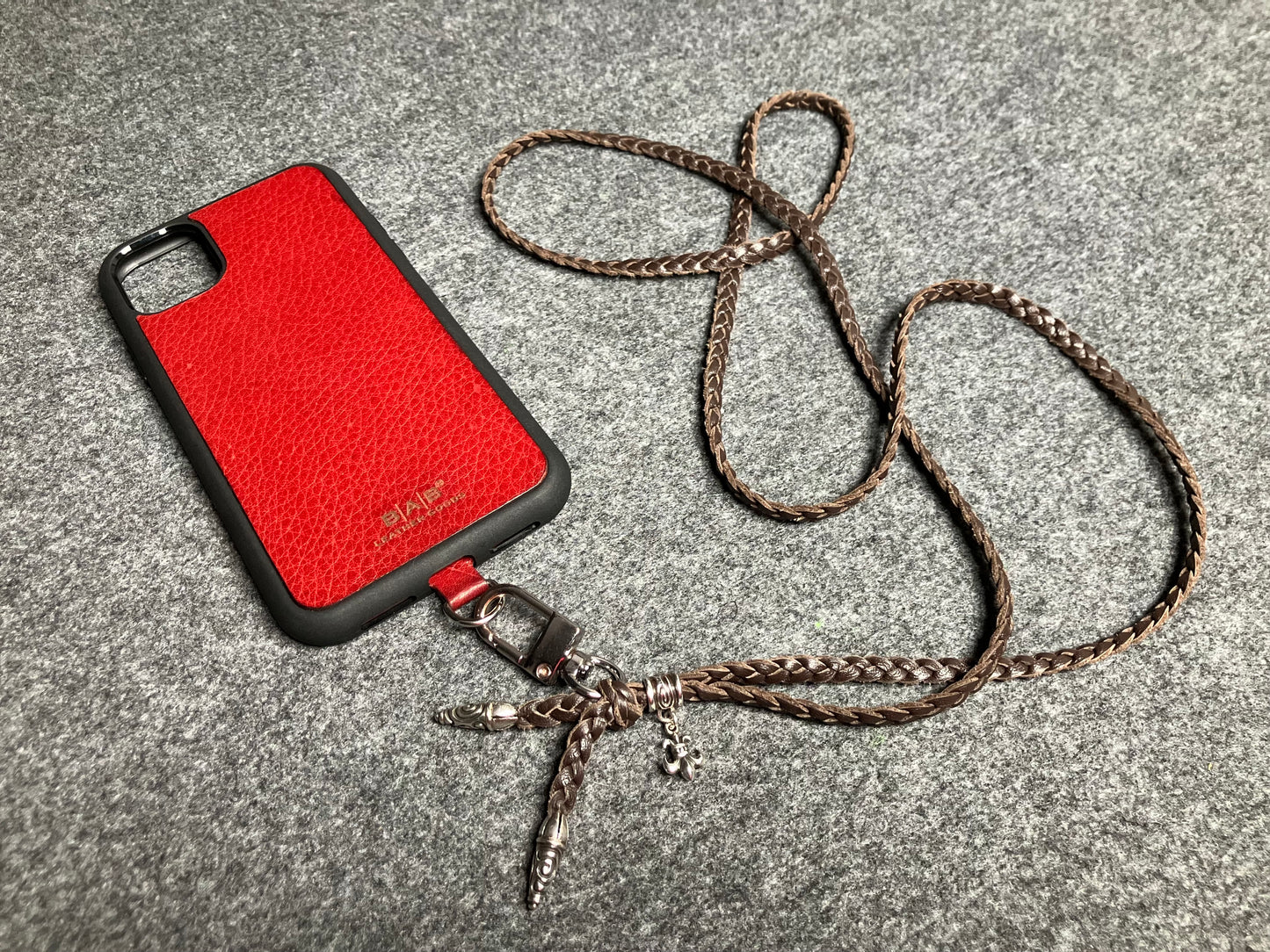 Capa/Suporte para iPhone de Couro Flor Integral/microfibra. 2 Terminais Espirais, 1 Pino em Espiral com Argola e 1 Pingente Fleur de Lys, todos de Prata 925 & Crossbody/Colar/Pulseira de Couro com 3 fios duplos trançados à mão, Marrom ou Preto.- KC45i