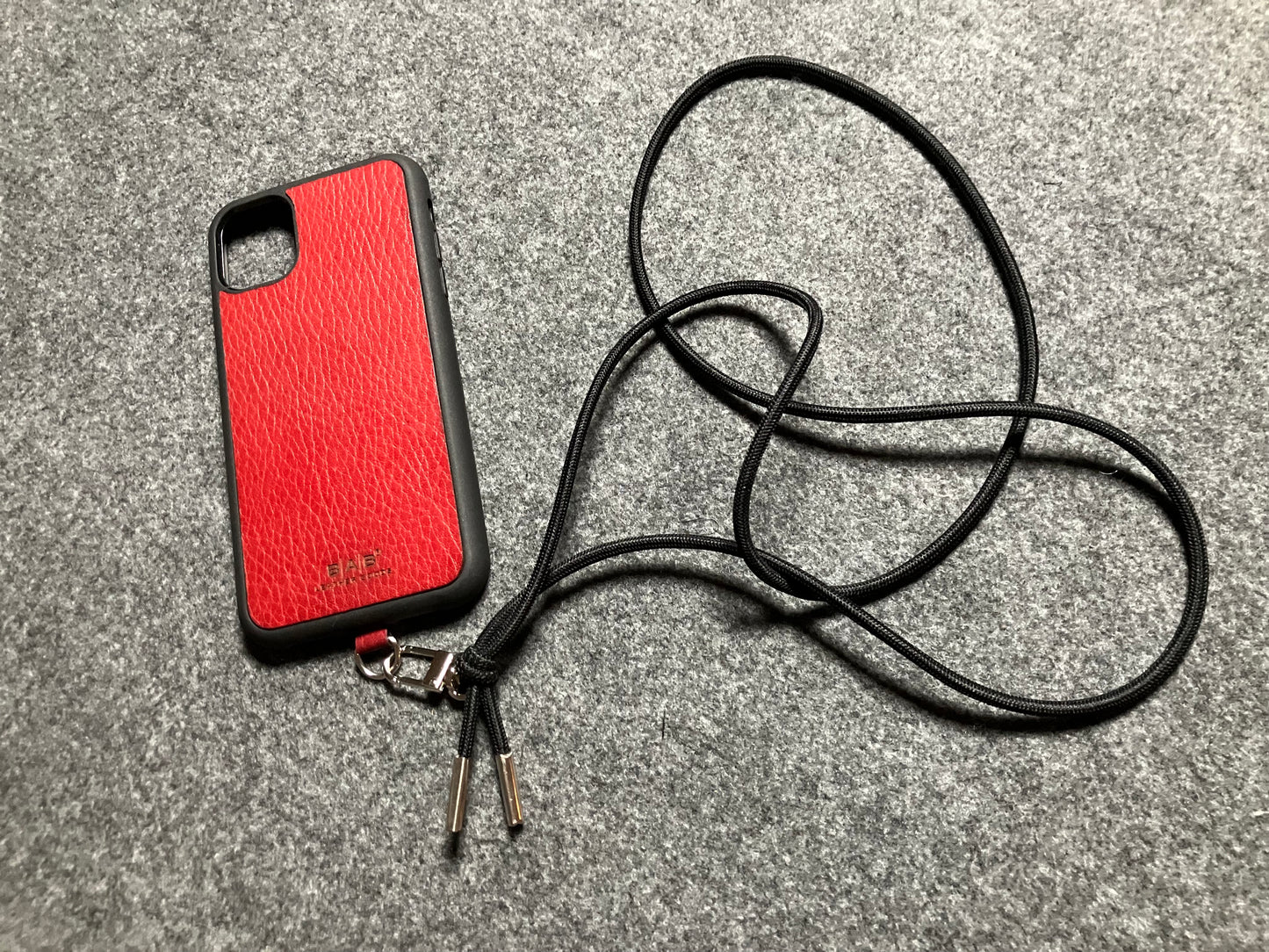 Funda/Soporte para iPhone de Cuero Genuino Full-Grain curtido vegetal al tanino cortados y grabados con láser/microfibra & Crossbody/Collar/Gargantilla/Pulsera de Cuerda Elástica Negra con 1 Mosquetón y 2 Terminales plateados.- KCi52