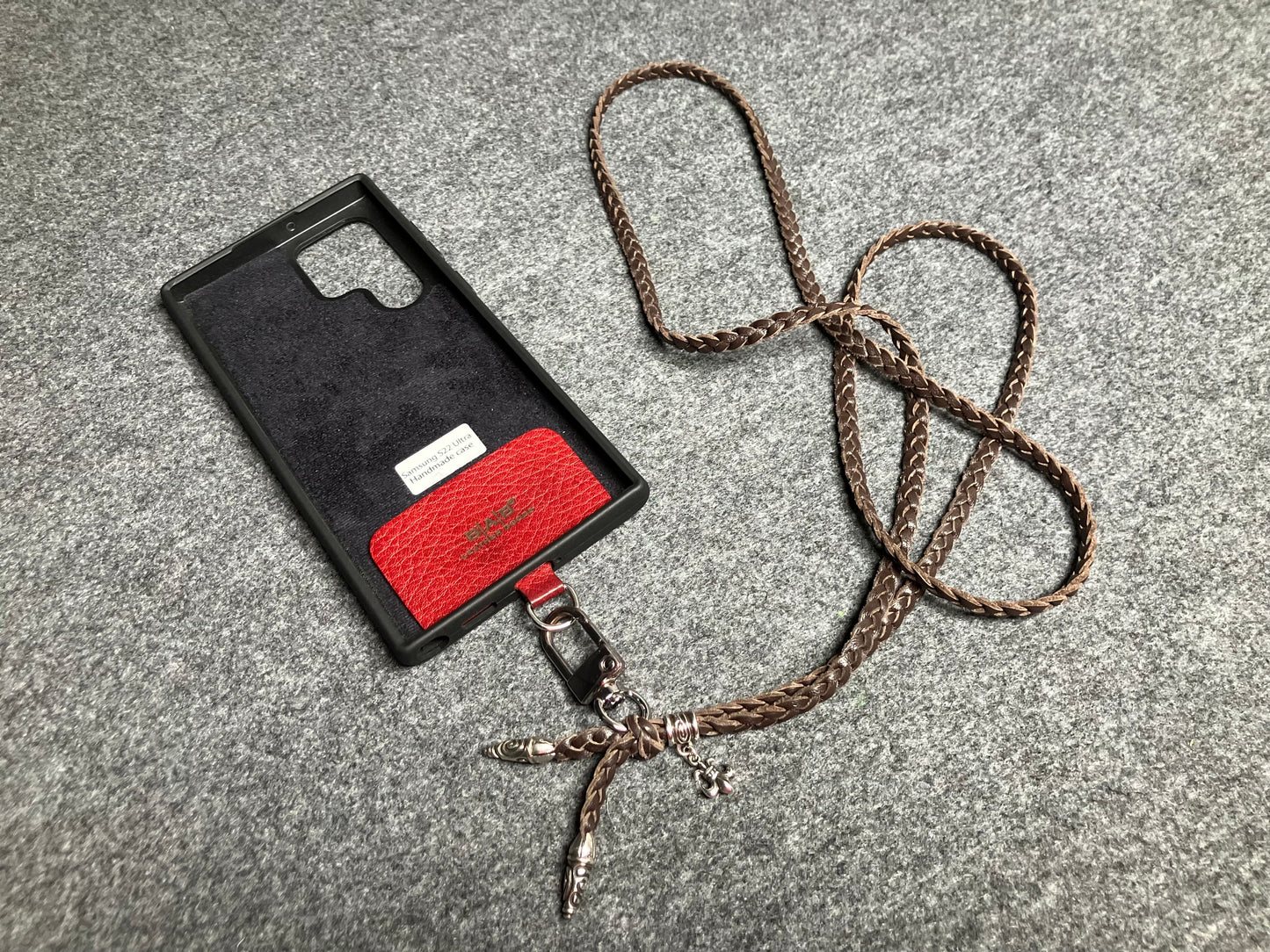 Capa/Suporte para Samsung de Couro Flor Integral/microfibra. 2 Terminais Espirais, 1 Pino em Espiral com Argola e 1 Pingente Fleur de Lys, todos de Prata 925 & Crossbody/Colar/Pulseira de Couro com 3 fios duplos trançados à mão, Marrom ou Preto.- KC45S