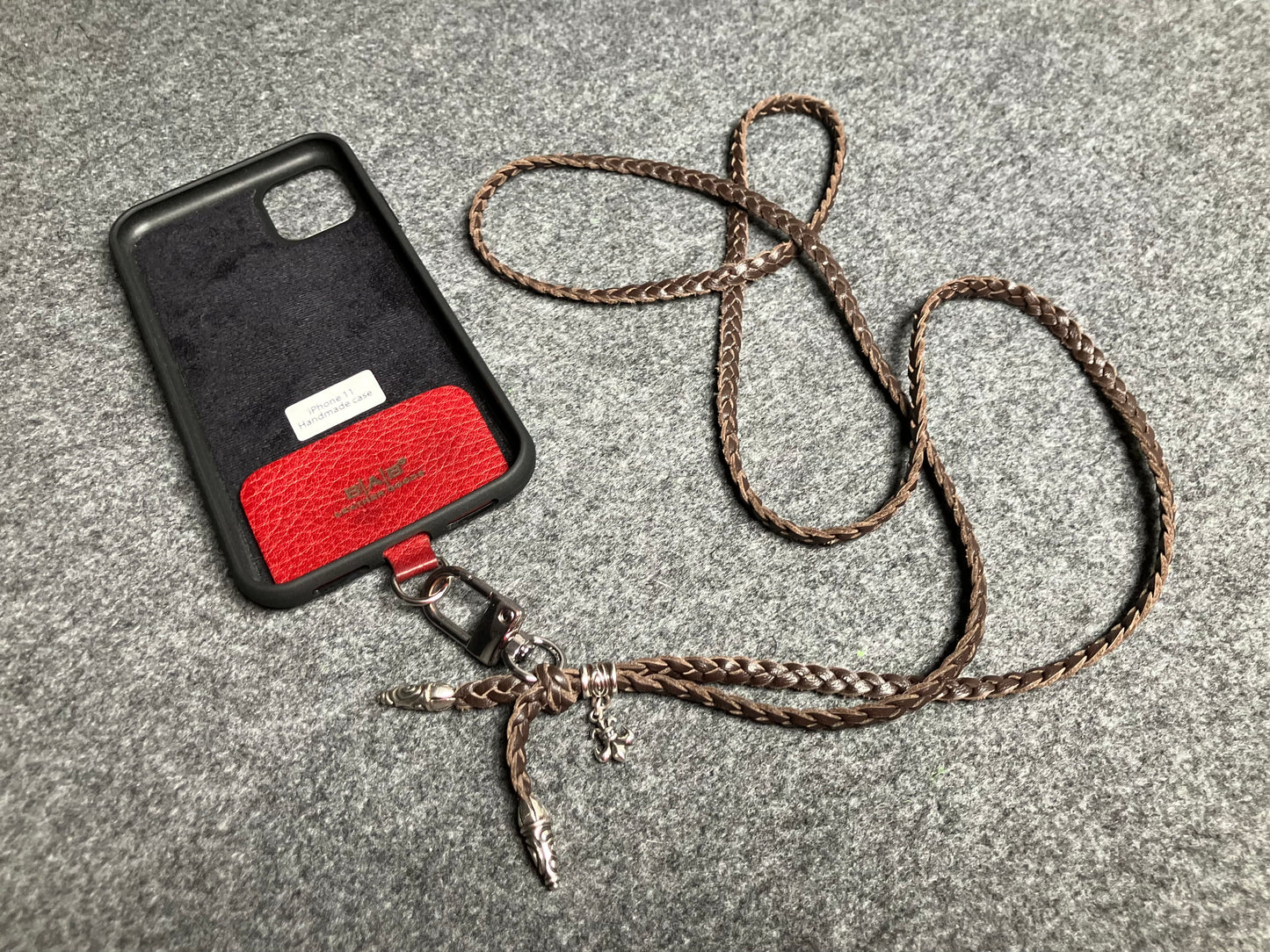 Capa/Suporte para iPhone de Couro Flor Integral/microfibra. 2 Terminais Espirais, 1 Pino em Espiral com Argola e 1 Pingente Fleur de Lys, todos de Prata 925 & Crossbody/Colar/Pulseira de Couro com 3 fios duplos trançados à mão, Marrom ou Preto.- KC45i