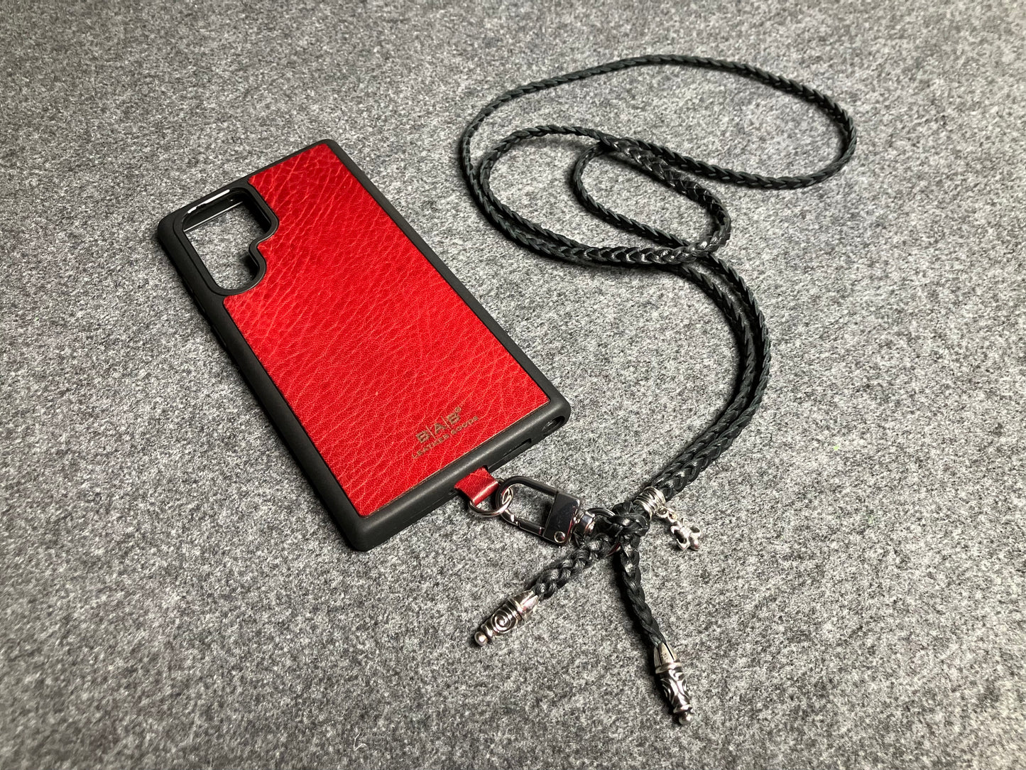 Capa/Suporte para Samsung de Couro Flor Integral/microfibra. 2 Terminais Espirais, 1 Pino em Espiral com Argola e 1 Pingente Fleur de Lys, todos de Prata 925 & Crossbody/Colar/Pulseira de Couro com 3 fios duplos trançados à mão, Marrom ou Preto.- KC45S