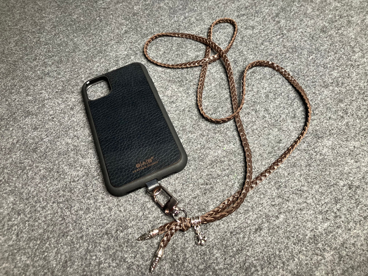 Capa/Suporte para iPhone de Couro Flor Integral/microfibra. 2 Terminais Espirais, 1 Pino em Espiral com Argola e 1 Pingente Fleur de Lys, todos de Prata 925 & Crossbody/Colar/Pulseira de Couro com 3 fios duplos trançados à mão, Marrom ou Preto.- KC45i