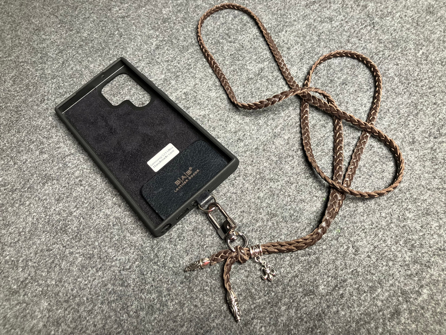Capa/Suporte para Samsung de Couro Flor Integral/microfibra. 2 Terminais Espirais, 1 Pino em Espiral com Argola e 1 Pingente Fleur de Lys, todos de Prata 925 & Crossbody/Colar/Pulseira de Couro com 3 fios duplos trançados à mão, Marrom ou Preto.- KC45S