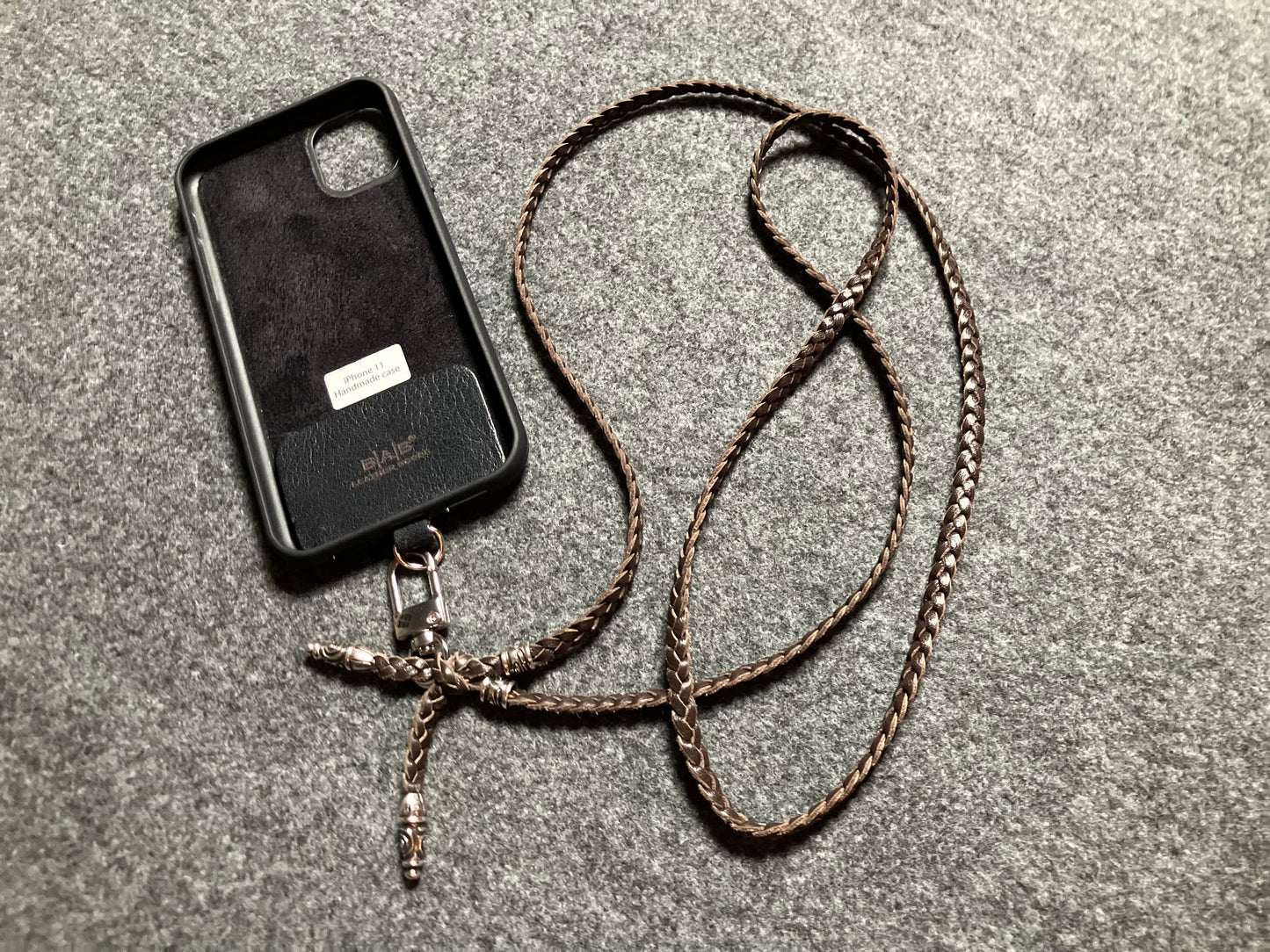 Capa/Suporte para iPhone de Couro Genuíno Flor Integral cortados e gravados a laser/microfibra. 2 Terminais Espirais e 2 Pinos Espirais, todos feitos de Prata 925 & Crossbody/Colar/Pulseira com três fios duplos trançados à mão, Marrom ou Preto.- KC43i