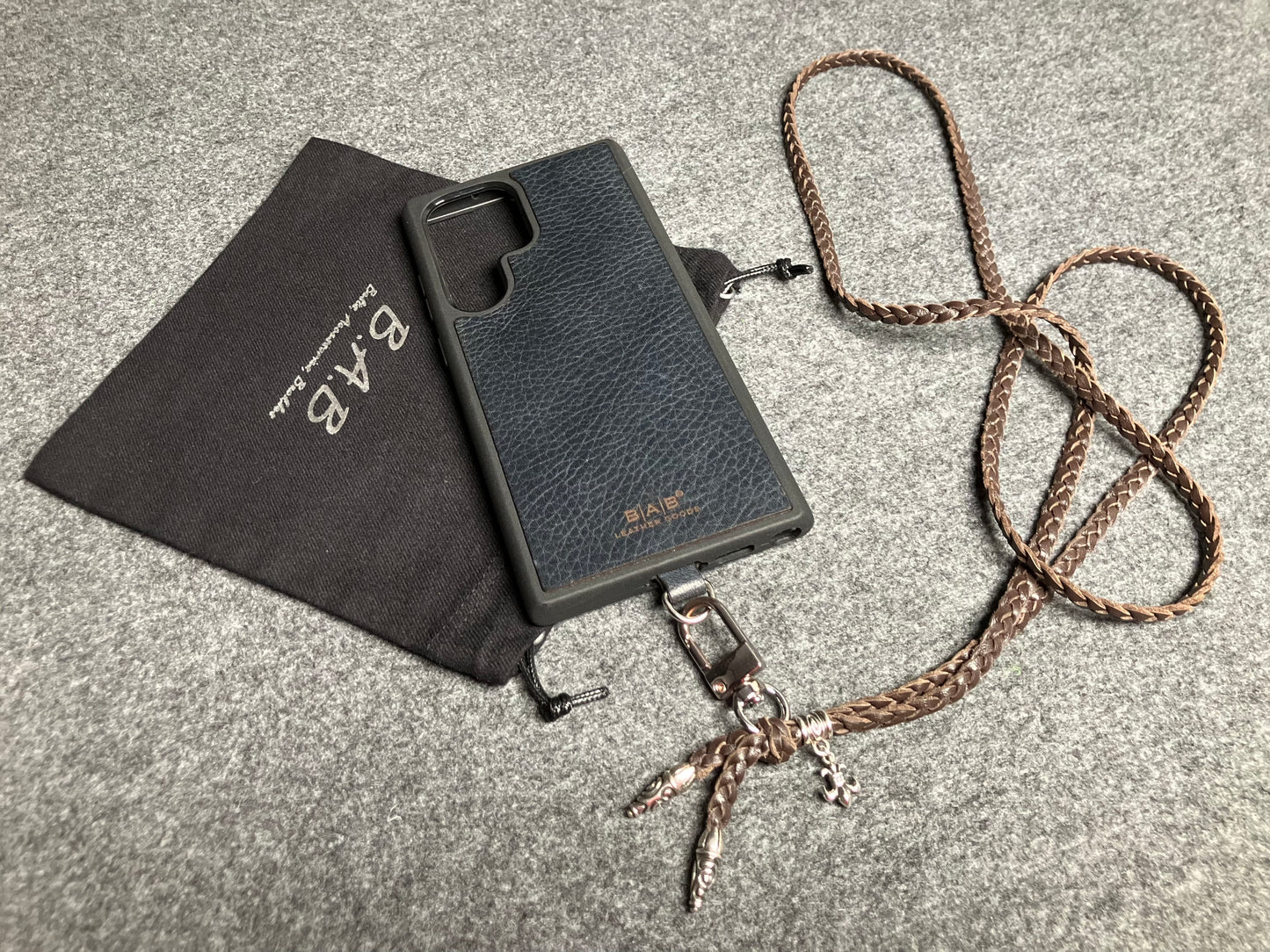 Capa/Suporte para Samsung de Couro Flor Integral/microfibra. 2 Terminais Espirais, 1 Pino em Espiral com Argola e 1 Pingente Fleur de Lys, todos de Prata 925 & Crossbody/Colar/Pulseira de Couro com 3 fios duplos trançados à mão, Marrom ou Preto.- KC45S