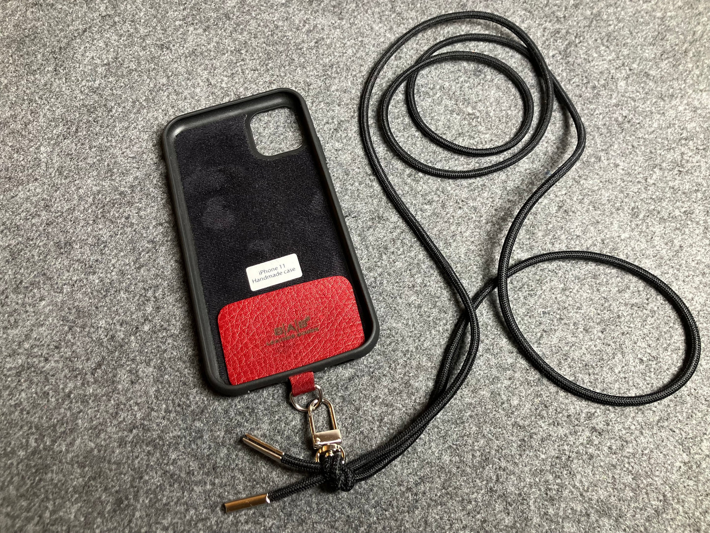 Support pour téléphone portable en Cuir Véritable Pleine Fleur tanné végétal au tanin gravé au laser & Bandoulière/Collier/Bracelet Cordon Élastique Noir, avec 1 Mousqueton et 2 Embouts argentés.- SC57