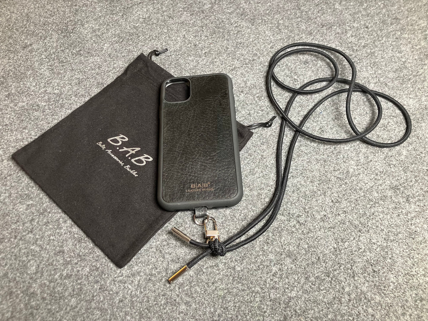 Support pour téléphone portable en Cuir Véritable Pleine Fleur tanné végétal au tanin gravé au laser & Bandoulière/Collier/Bracelet Cordon Élastique Noir, avec 1 Mousqueton et 2 Embouts argentés.- SC57