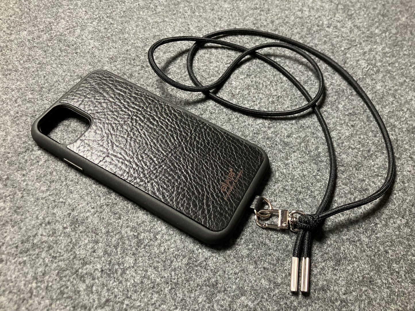 Funda/Soporte para iPhone de Cuero Genuino Full-Grain curtido vegetal al tanino cortados y grabados con láser/microfibra & Crossbody/Collar/Gargantilla/Pulsera de Cuerda Elástica Negra con 1 Mosquetón y 2 Terminales plateados.- KCi52