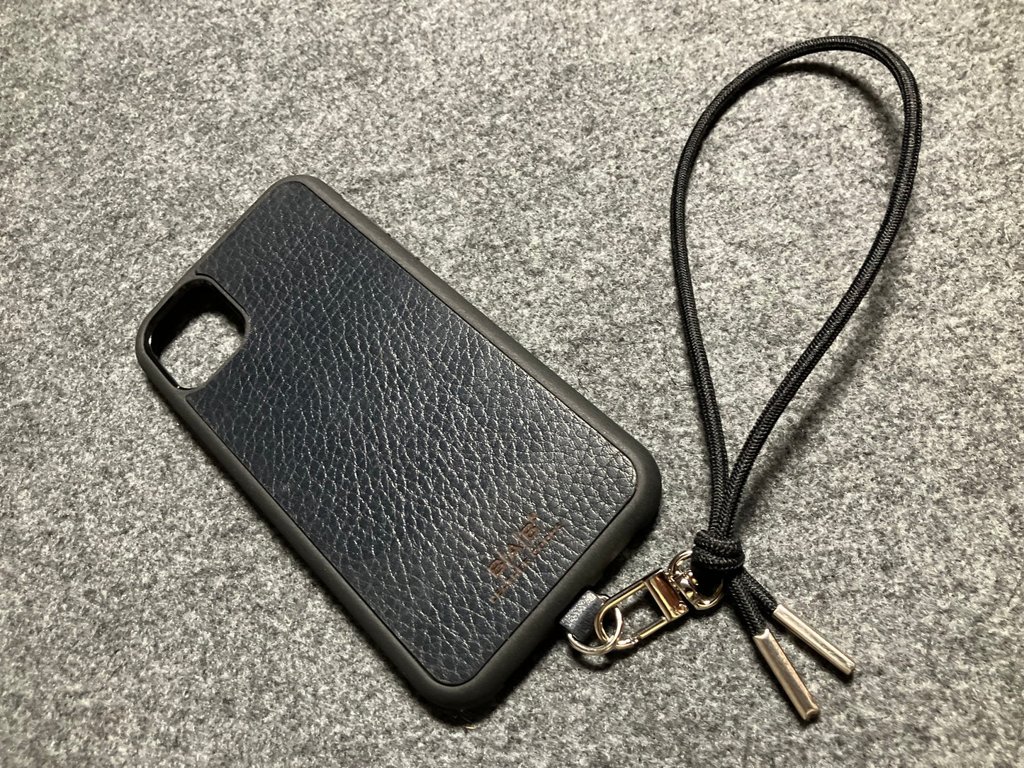 Capa/Suporte para iPhone de Couro Genuíno Flor Integral curtido vegetal com tanino cortados e gravados a laser/microfibra & Correia/Pulseira de Corda Elástica Preta com 1 Mosquetão e 2 Terminais prateados.- KPi54 