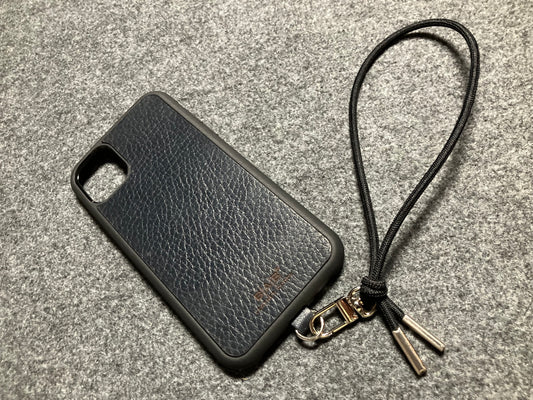 Funda/Soporte para iPhone de Cuero Genuino Full-Grain curtido vegetal al tanino cortados y grabados con láser/microfibra & Correa/Pulsera de Cuerda Elástica Negra con 1 Mosquetón y 2 Terminales plateados.- KPi54