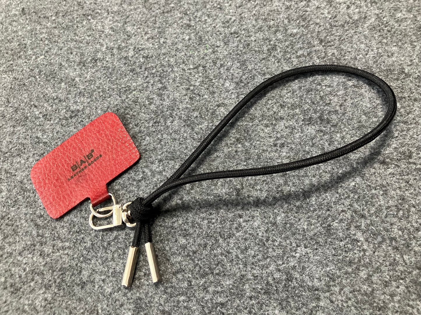 Laser-engraved Full-Grain vegetable-tanned Genuine Leather cell phone Holder & Black Elastic Rope Strap/Bracelet with a Carabiner, and 2 Silver End caps.- SP56