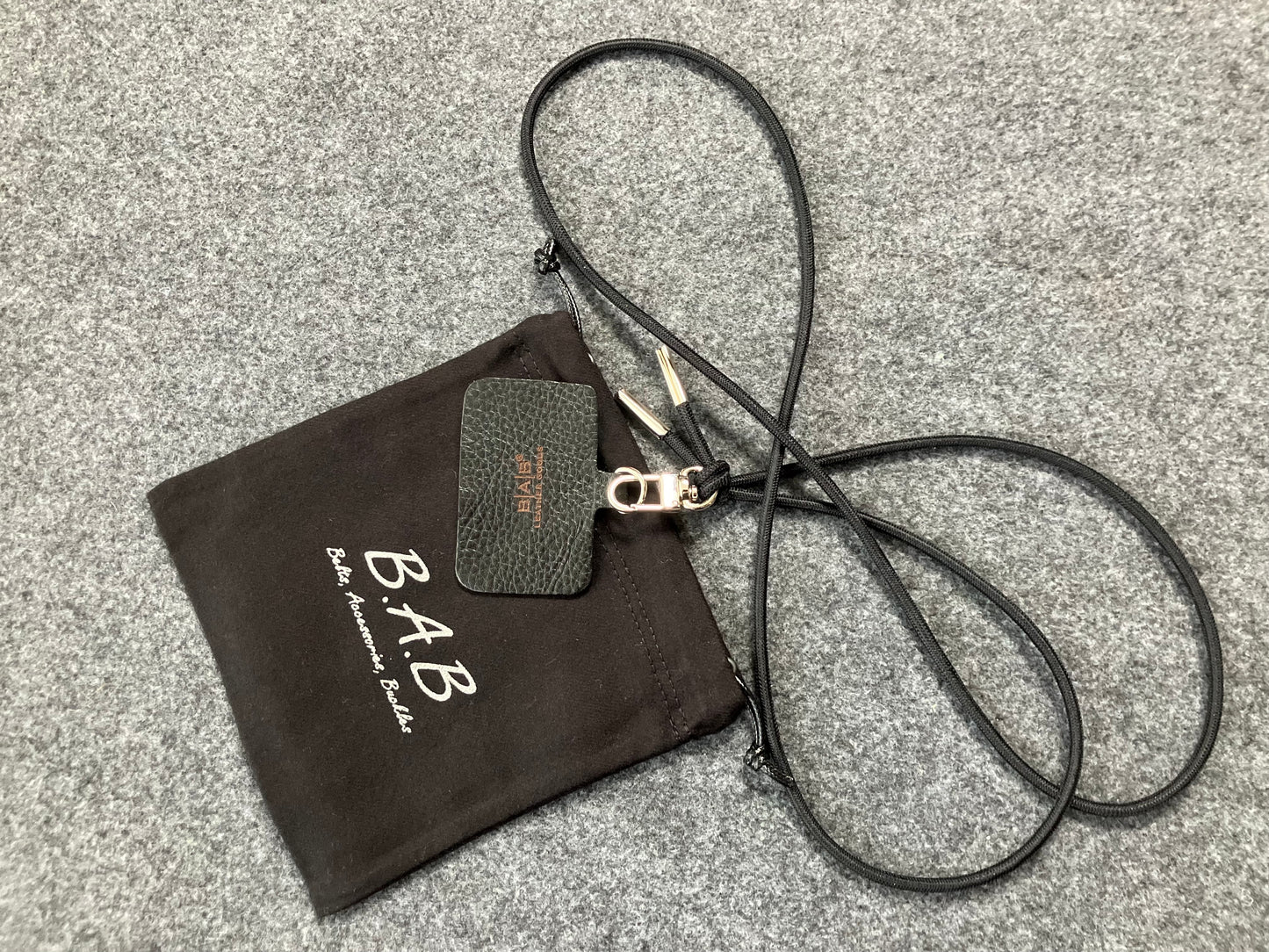 Support pour téléphone portable en Cuir Véritable Pleine Fleur tanné végétal au tanin gravé au laser & Bandoulière/Collier/Bracelet Cordon Élastique Noir, avec 1 Mousqueton et 2 Embouts argentés.- SC57