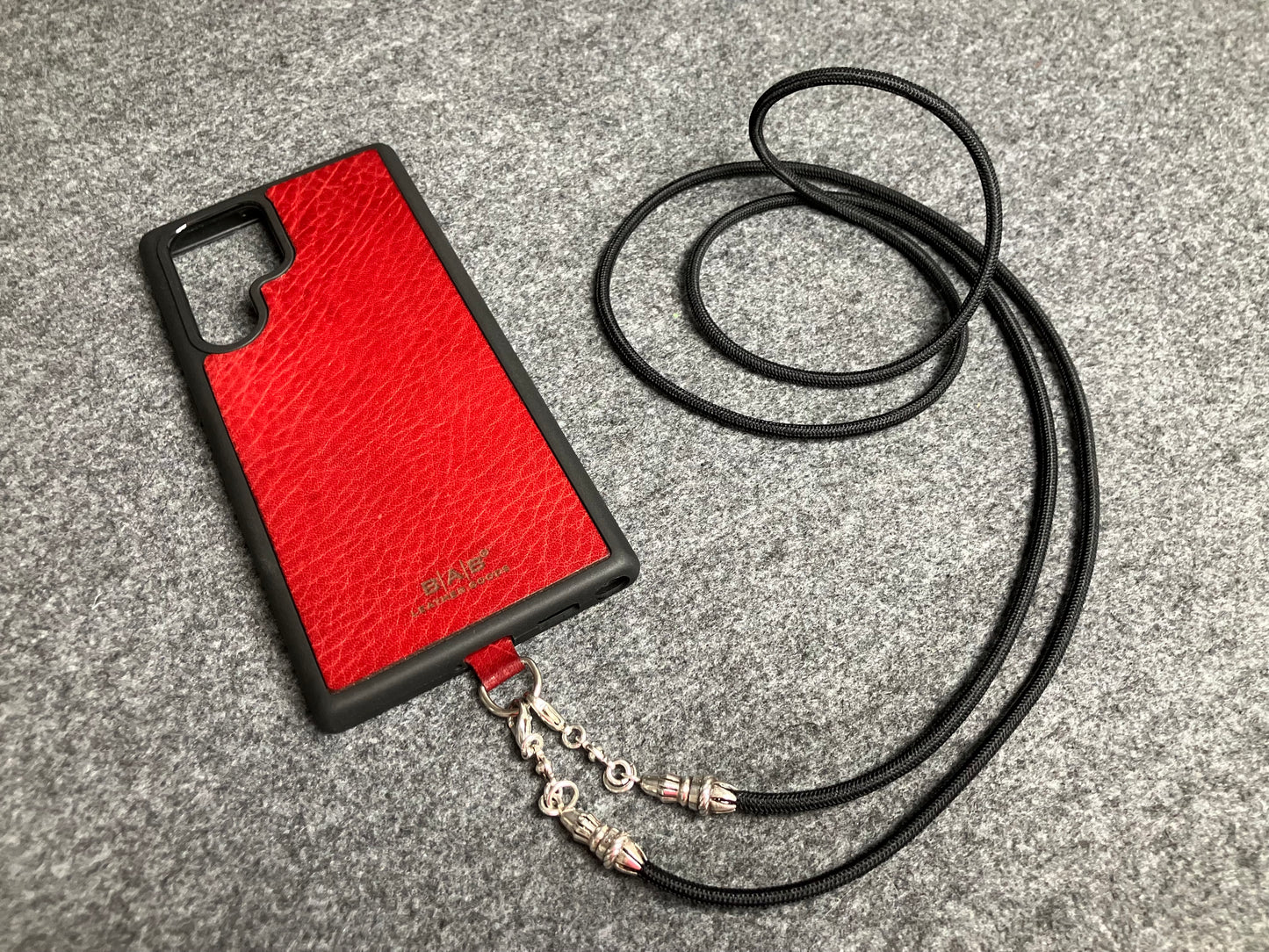 Funda/Soporte de Cuero Genuino Full-Grain curtido vegetal al tanino para Samsung/microfibra. 2 Terminales Cuerda, 2 Eslabones y 6 Argollas, todos de Plata Esterlina 925 & Crossbody/Collar/Gargantilla/Pulsera de Cuerda Elástica Negra.- KC29S