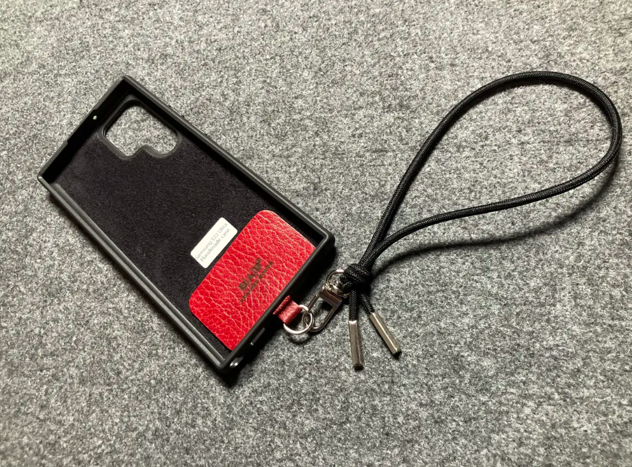 Capa/Suporte para Samsung de Couro Genuíno Flor Integral curtido vegetal com tanino cortados e gravados a laser/microfibra & Correia/Pulseira de Corda Elástica Preta com 1 Mosquetão e 2 Terminais prateados.- KPS55